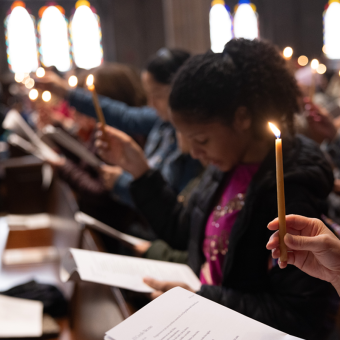Congregants hold lit candles during a service in Trinity Church