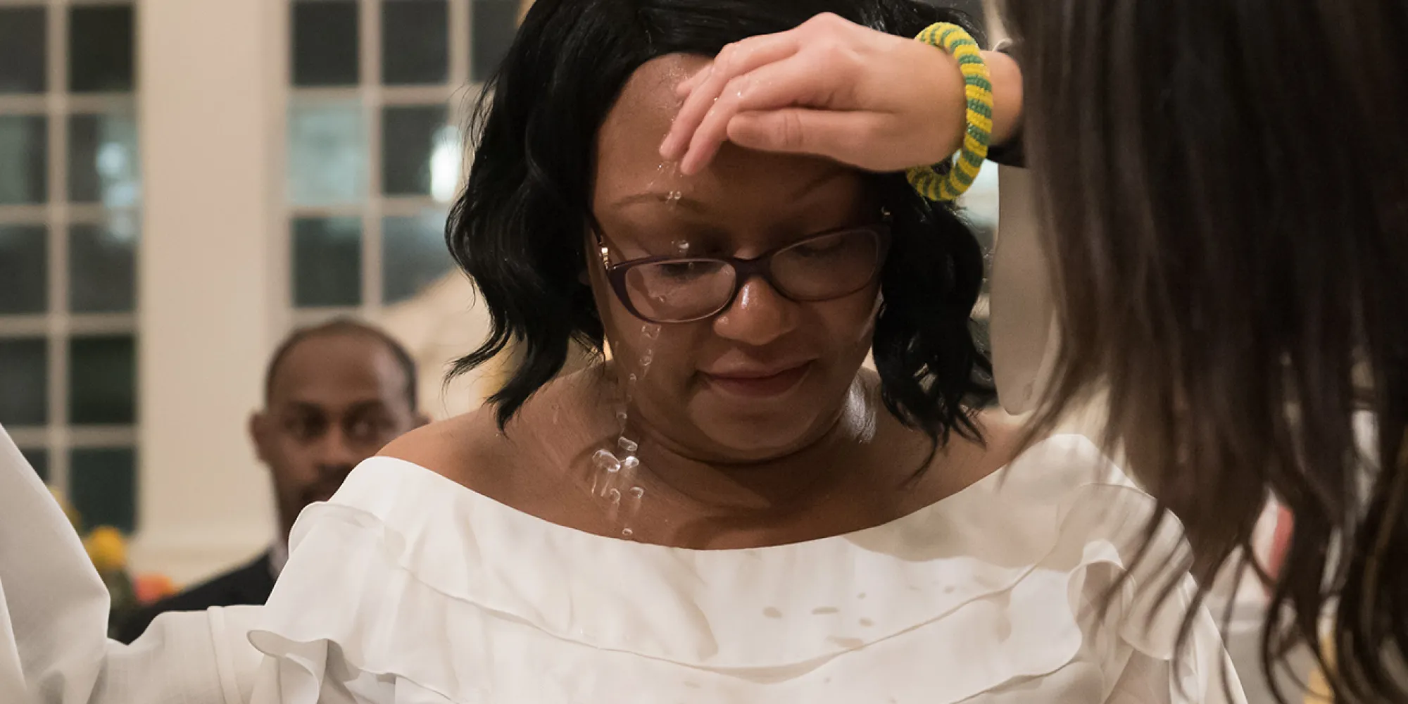 Priest baptizing woman