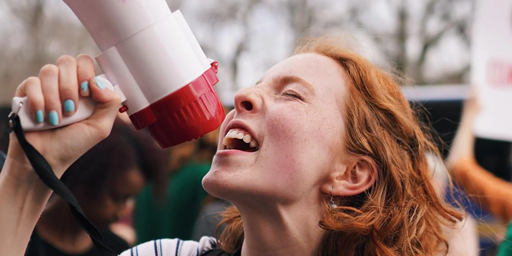 Parishioner Azalea Danes at Climate March with a megaphone