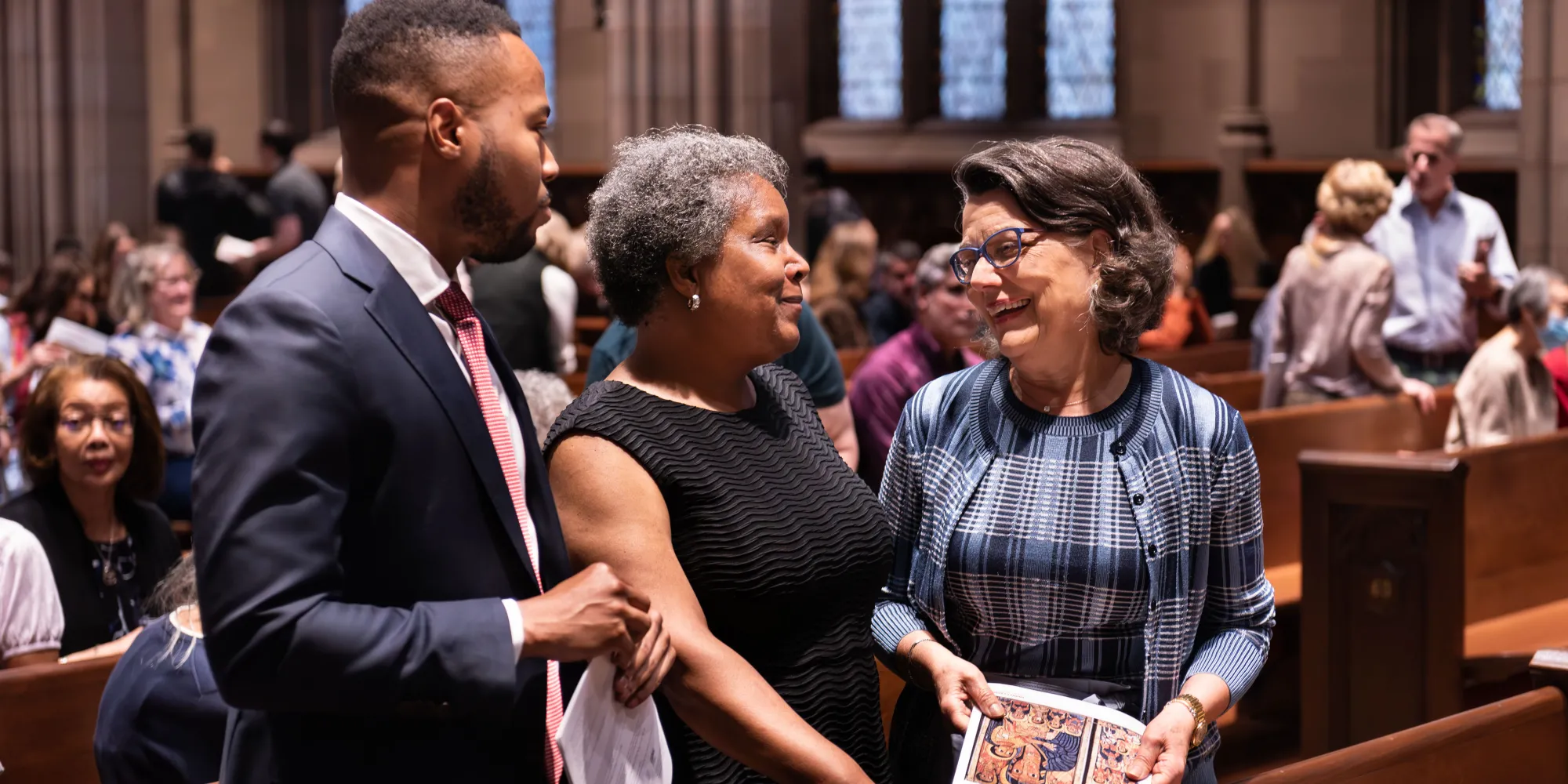 Three parishioners chat before a Sunday service in Trinity Church.