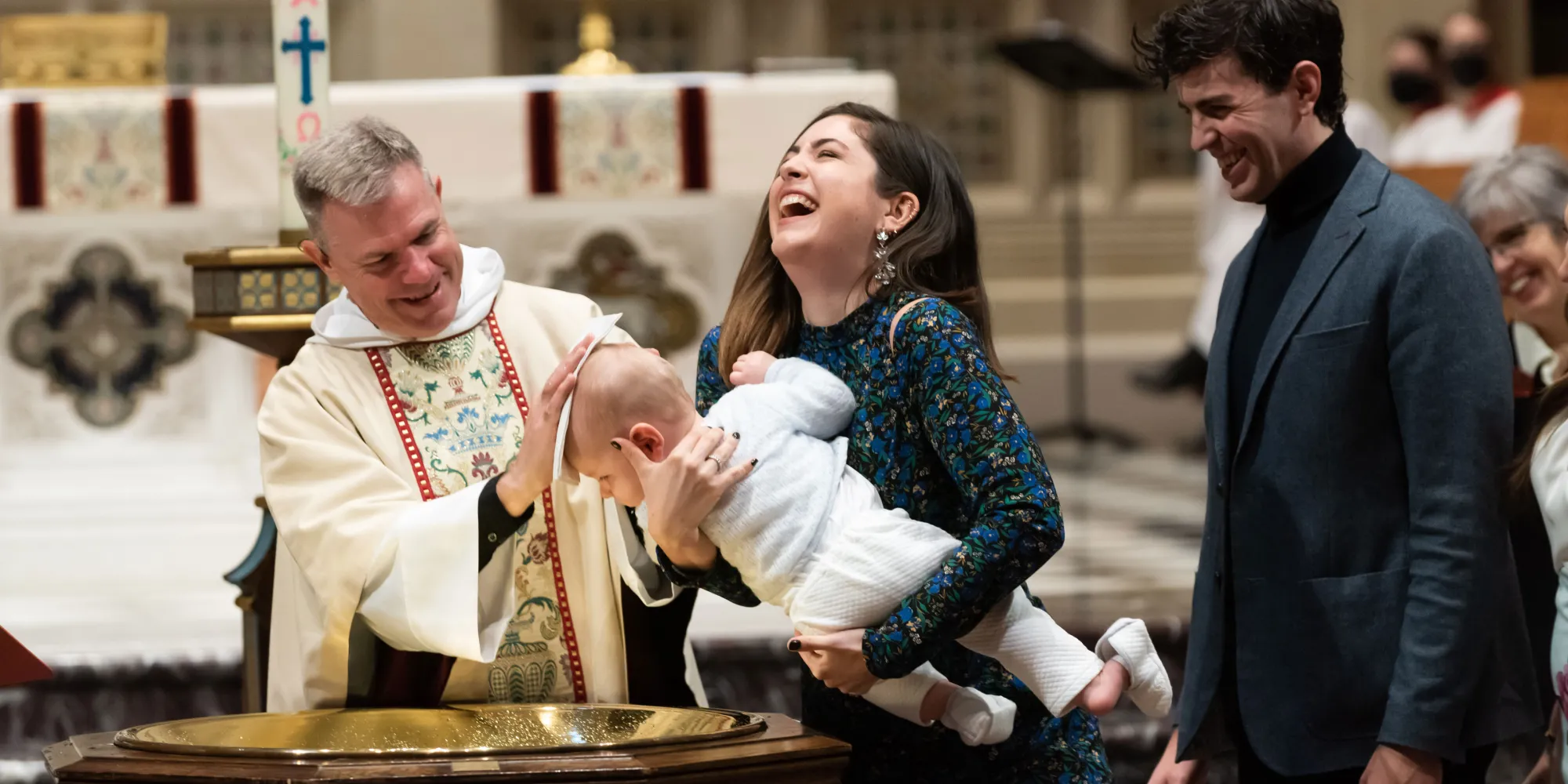 Father Bird joyfully baptizes a baby, mom and dad laugh.