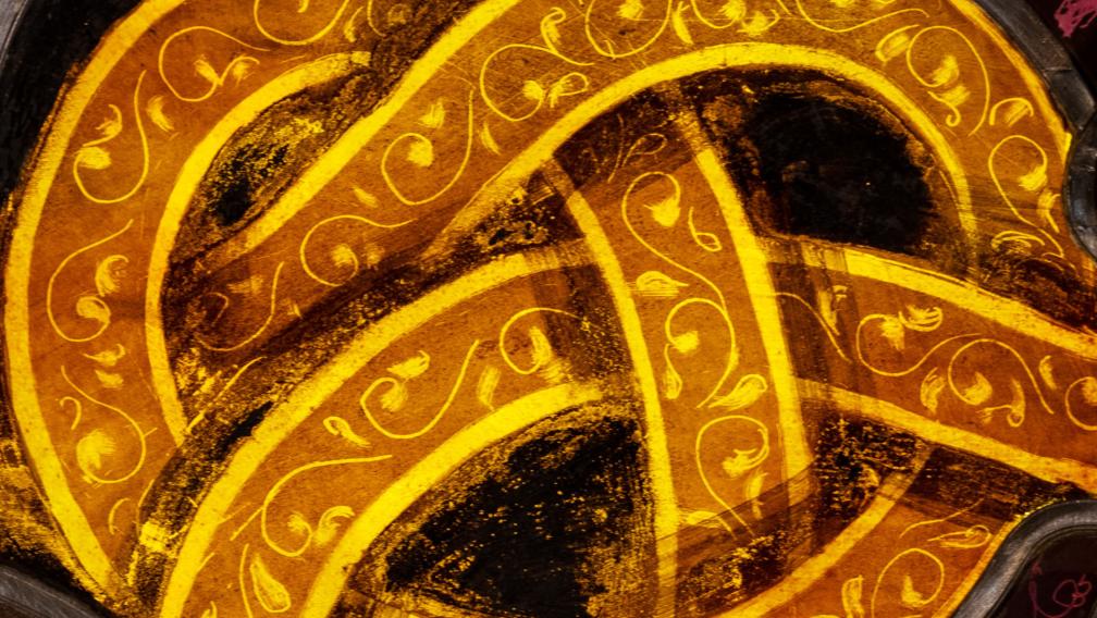A close-up of a stained glass window depicting a golden knot