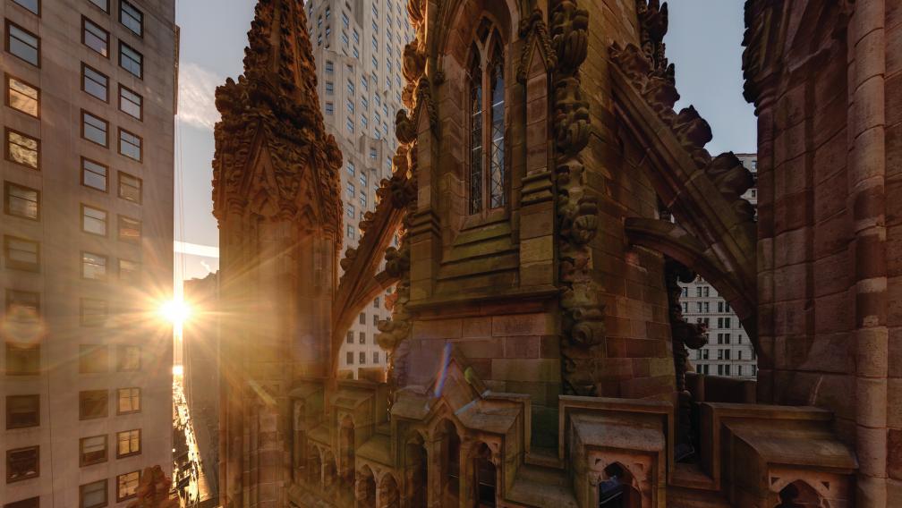 A panorama shot of the top of Trinity Church Wall Street's steeple, with the sun rising to the left.