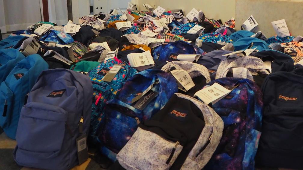Backpacks filled with school supplies line the floor of St. Paul's Chapel