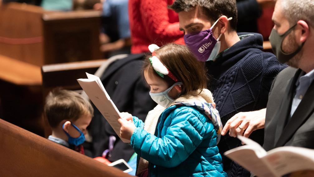 A family looks through the worship bulletin together in Trinity Church