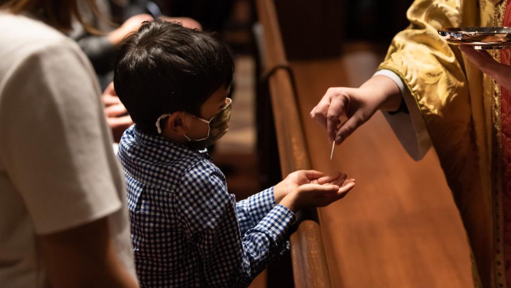 A child receives a communion wafer in Trinity Church