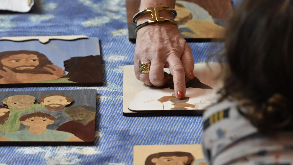 An adult hand pointing to drawings of people from the Bible during Children’s Time