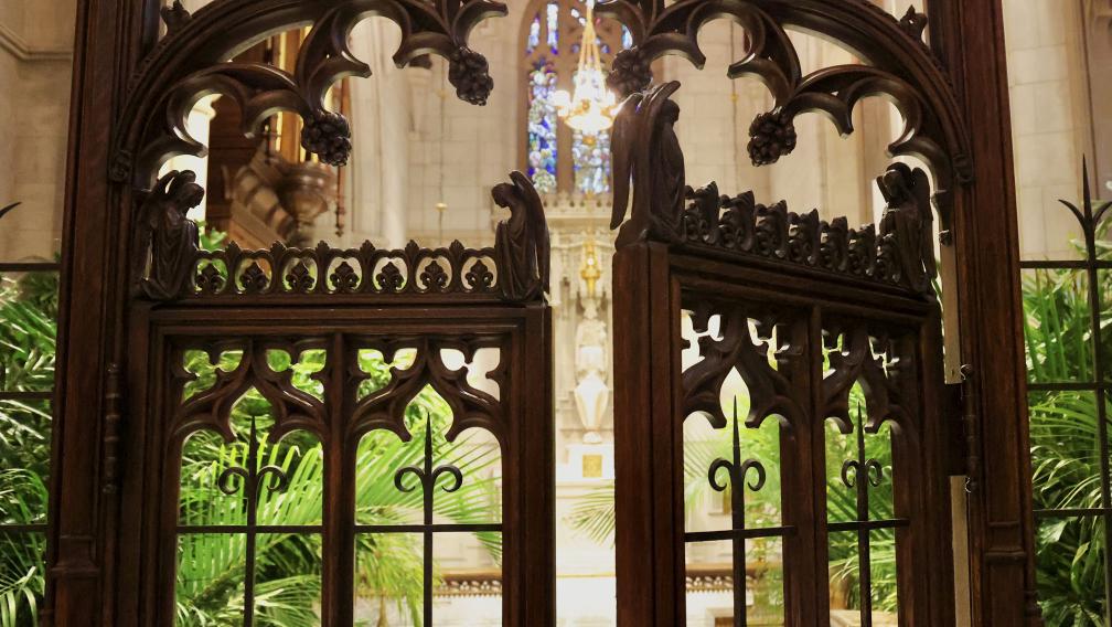Carved wooden gates open into the Chapel of All Saints at Trinity Church, filled with palms from Palm Sunday