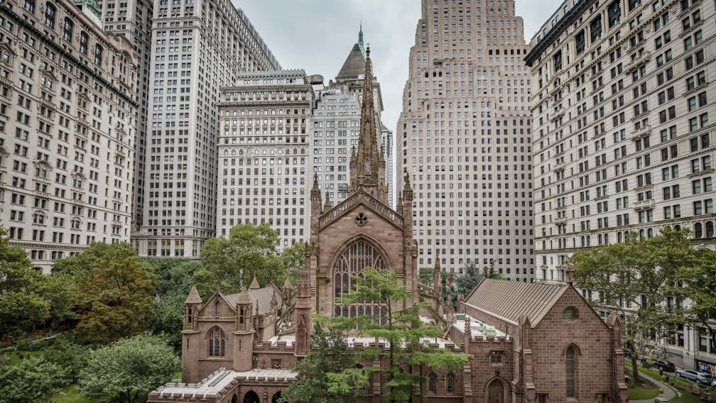 Exterior of Trinity Church with buildings and trees around it.