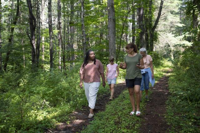 Former campers and counselors, including Anne Clarke-Raysor (front left), explore the grounds of the Trinity Retreat Center. 