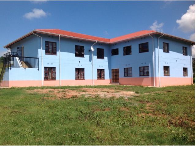An exterior shot of the women's dormitory in Swaziland. The building is blue with a terracotta roof.