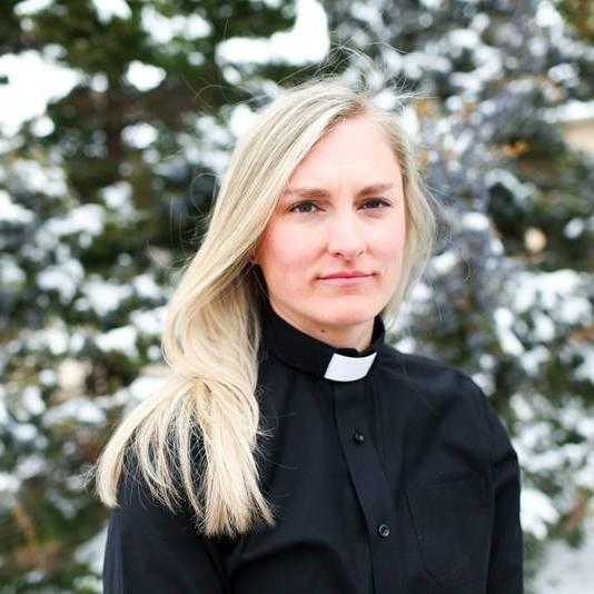 The Rev. Sarah Smith looks at the camera in front of a snowy landscape that's out of focus.