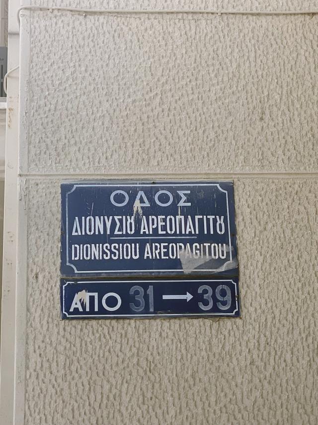 Blue street sign with white Greek letters 