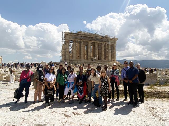 Group of people stand in front of ancient temple