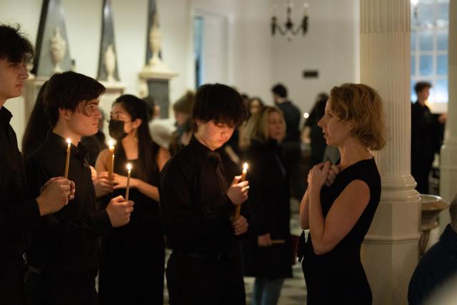 Melissa Attebury, at right, stands before three Youth Choristers holding candles