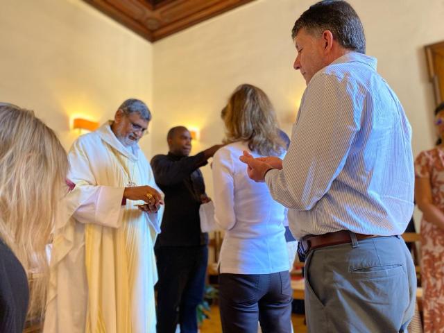 People stand before a priest waiting for communion