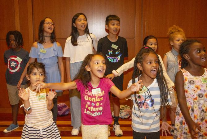 Children perform a song in Trinity Commons during the 2023 Summer Program
