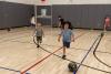 Two boys playing soccer in the Trinity Commons gymnasium 