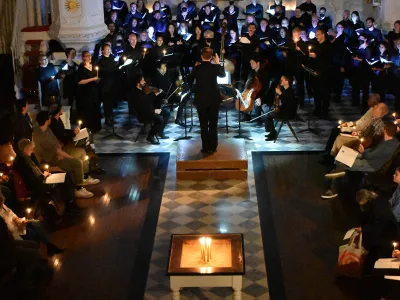 Large group of singers from above in candlelit St. Paul's Chapel 