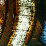 A close-up of a blue, yellow, orange, and white section of stained glass in the Chapel of All Saints at Trinity Church Wall Street