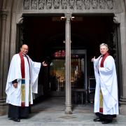 Phil Jackson and Michael Bird welcome parishioners back to Trinity Church.