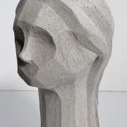 A gray slay sculpture of an abstract human bust