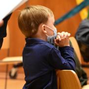 A child prays during Family Service in Parish Hall
