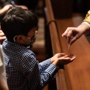 A child receives a communion wafer in Trinity Church