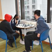 Students are playing chess with Youth Advisor