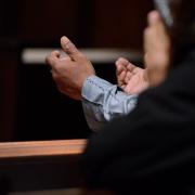 A person lifts up their hands in prayer in Trinity Church