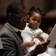 A man holds a child during Holy Eucharist at Trinity Church