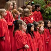 The children's choir in red choir robes singing in Trinity Church
