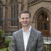 Neill Coleman stands in front of Trinity Church