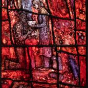 Stained-glass window closeup of woman feeding a person in need.