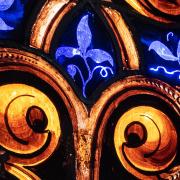 Stained glass with gold swirls and blue plant tendrils
