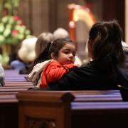 A child and caregiver sitting in a pew during the 9am service at Trinity Church