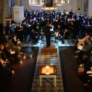 Large group of singers from above in candlelit St. Paul's Chapel 