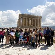 Group of people stand in front of ancient temple