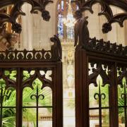 Carved wooden gates open into the Chapel of All Saints at Trinity Church, filled with palms from Palm Sunday