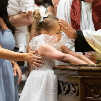 A child is baptized in Trinity Church on Pentecost Day