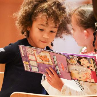 Two children look at an activity book during Family Service at Trinity Commons