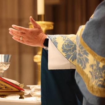 A hand stretched out over the table during Holy Eucharist at Trinity Church