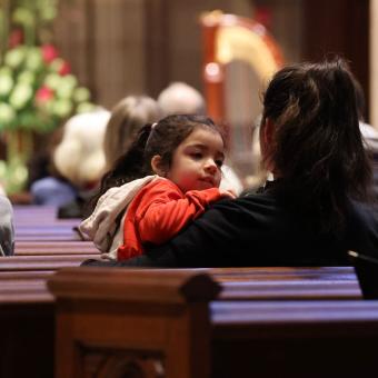 A child and caregiver sitting in a pew during the 9am service at Trinity Church