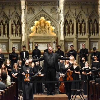Stephen Sands stands in front of Downtown Voices with his arms outstretched after a performance at Trinity Church