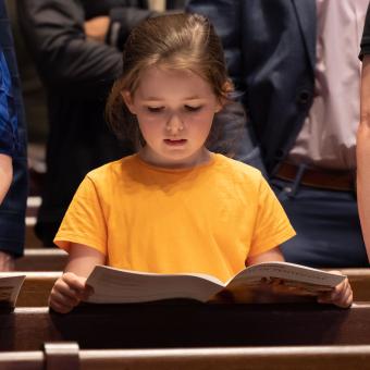 A child following along with the service using the worship bulletin at the 9:15am service