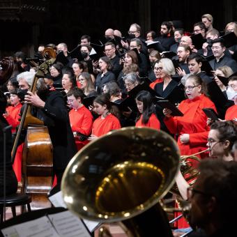 Choir members, a bass and tuba in red and black for holiday concert