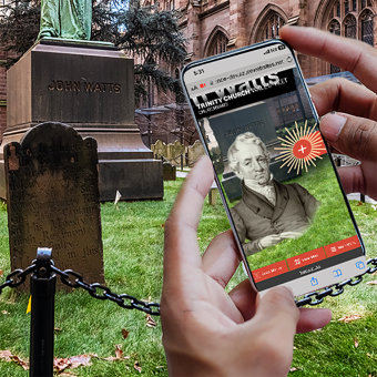 Hands holding a phone with the AR app showing in the Trinity Churchyard