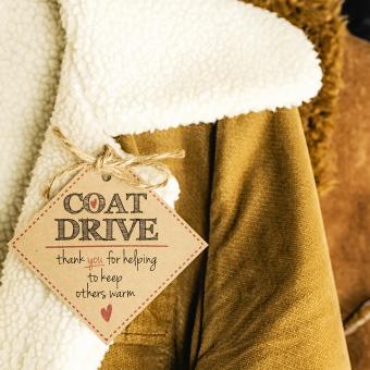 Image of winter coats, with a tag reading: COAT DRIVE - thank you for helping to keep others warm
