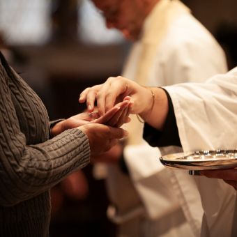 A close-up image of hands serving Communion in Trinity Church