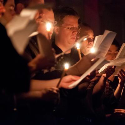 People at Compline holding candles and service programs